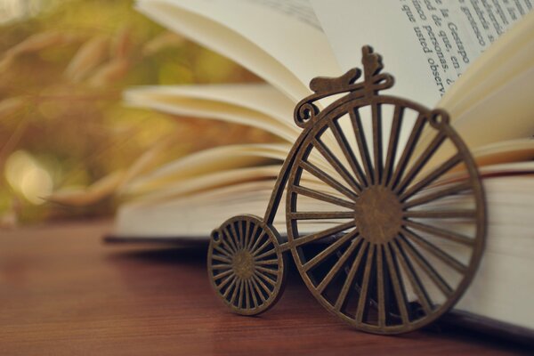 Figura de bicicleta antigua frente a un libro