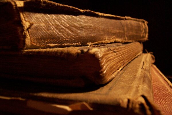 A stack of ancient folios of books on a black background