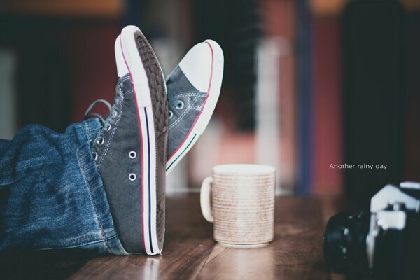 Tavolo in legno su cui tavolo macchina fotografica e scarpe da ginnastica