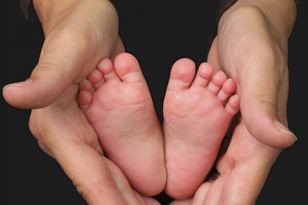 The image of the mother s hands and the baby s legs