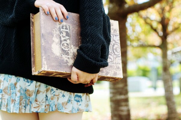 Fille avec un livre d amour avec une manucure bleue