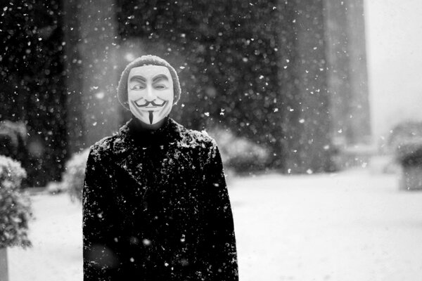 Mann in guy Fawkes Maske unter Schneefall