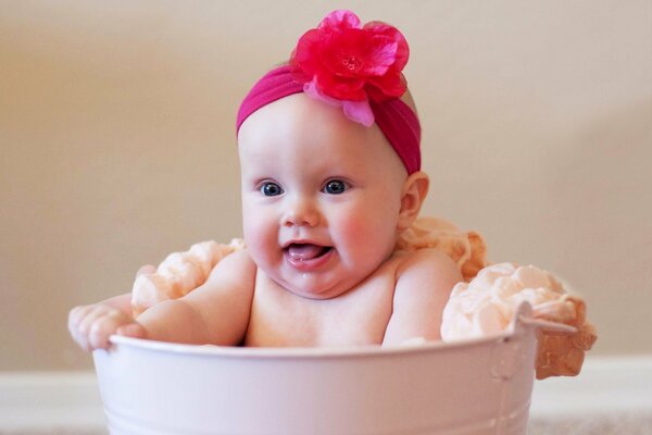 Adorable bébé dans un seau avec une éponge