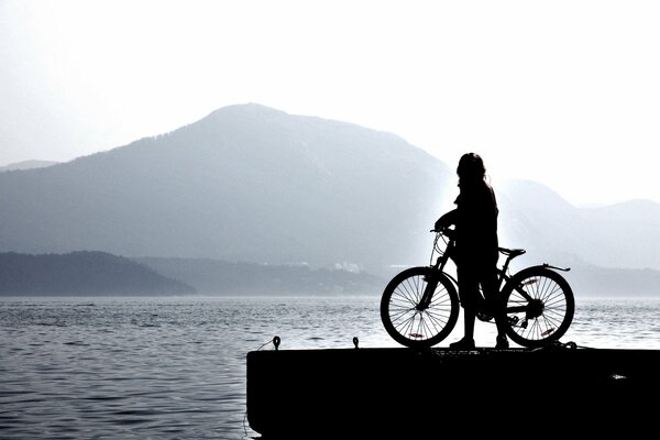 Homme sur un vélo près d un plan d eau