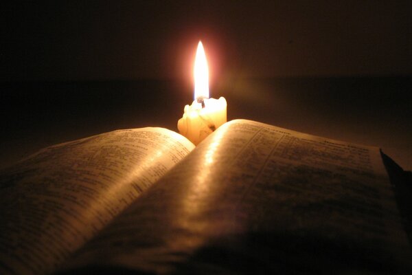 The candle burns beautifully over the book