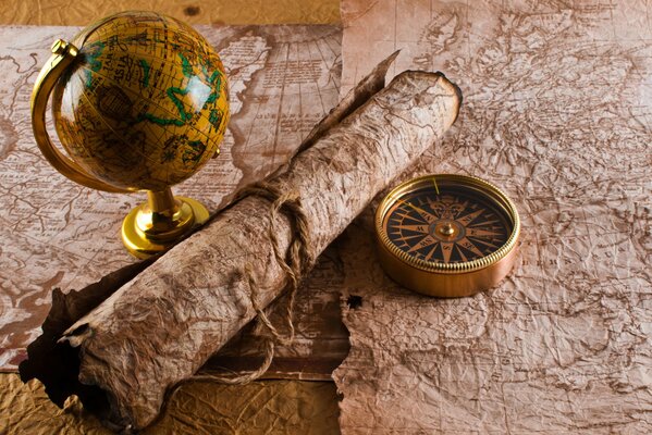 The old manuscript is rolled up and lies next to the compass