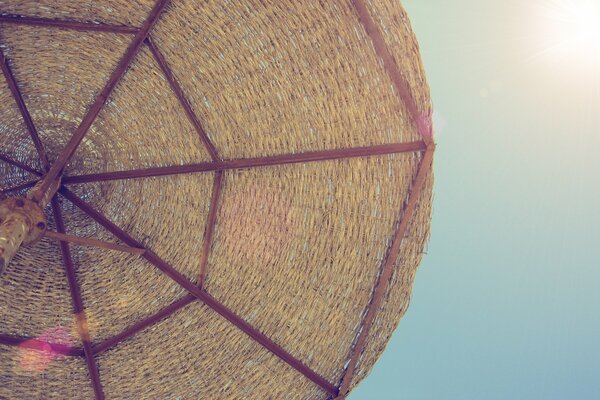 On the beach under an umbrella under the rays of the sun