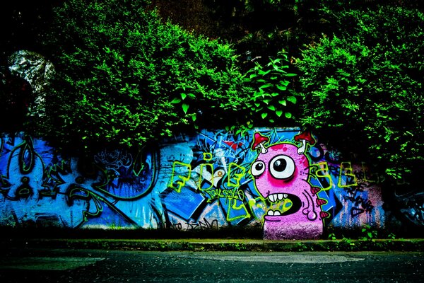 Graffiti na ścianie. Potwór z muchomorami na głowie