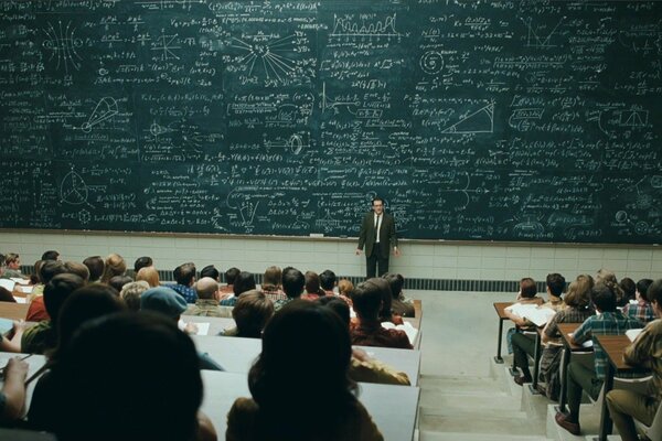 Conférence avec des formules sur un tableau noir devant les étudiants