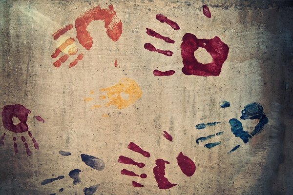 The handprints on the concrete wall are multicolored