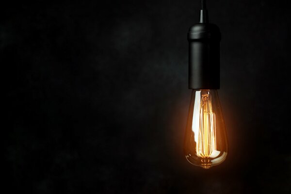 Электрическая лампочка как символ света во тьме