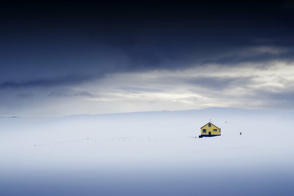 Ein einsames Haus in einem schneebedeckten Feld