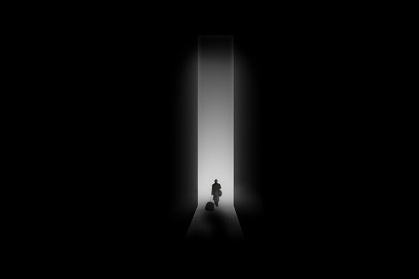 A man walking into a glowing doorway in the dark