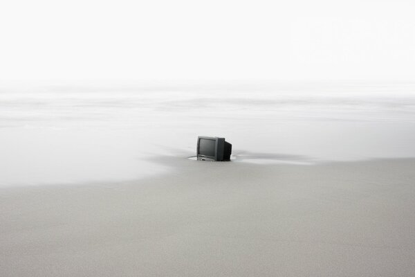 Am Meer steht ein Fernseher an einem einsamen Strand