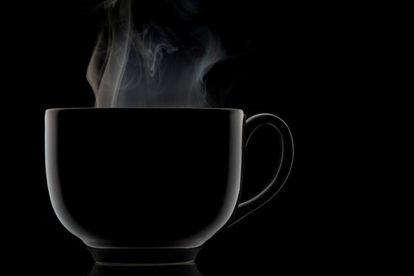 A black mug with steam coming out of it on a black background