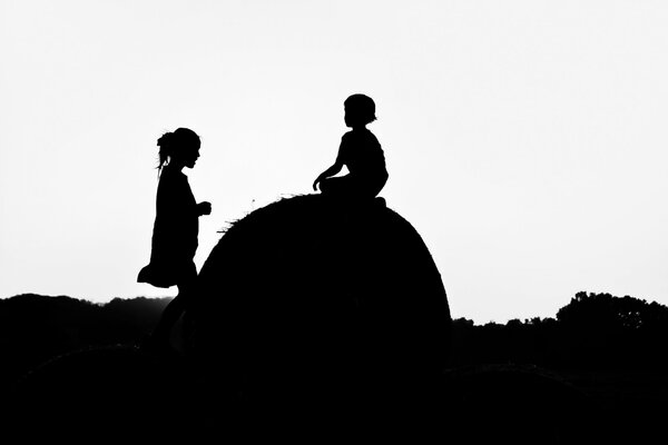 Silhouetten von Kindern auf einem Heuhaufen