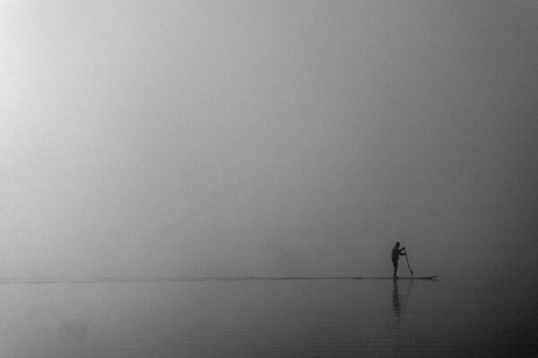 Ein Mann im Nebel, der sich mit dem Sapurfing am Meer beschäftigt