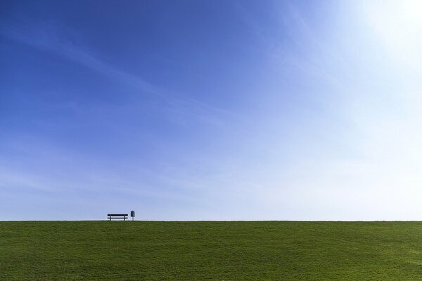 Banc sur fond de ciel et champ vert