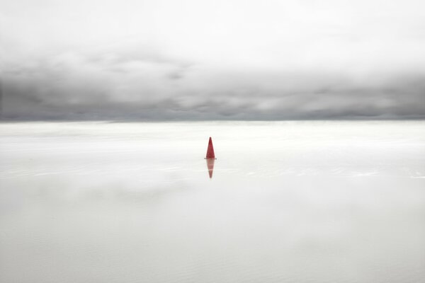 Calm sea. Cloudy sky and a lonely sign