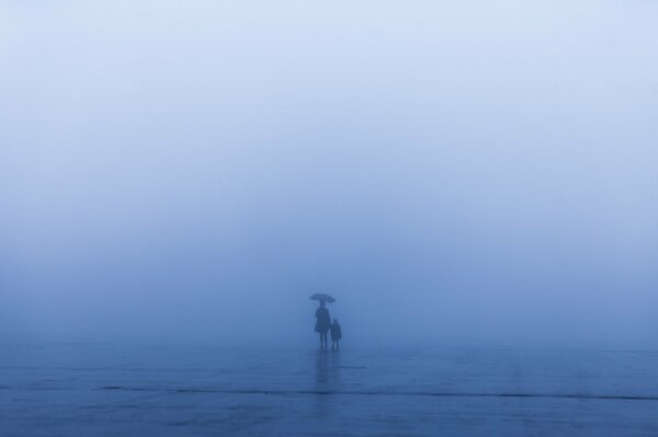 Femme avec un enfant sous un parapluie dans une tempête