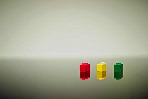 Tres bloques de LEGO de color rojo, amarillo y verde