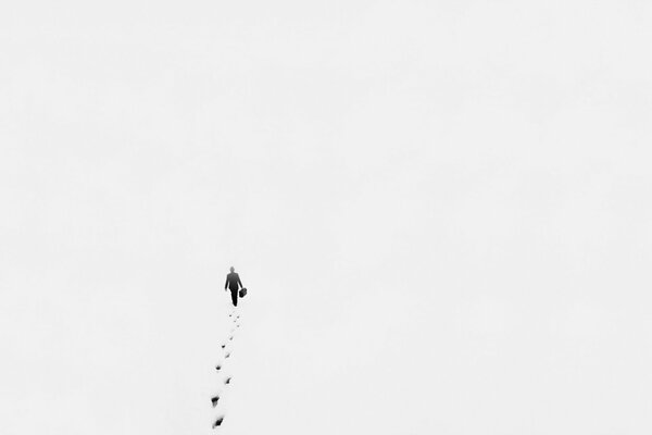 Ein Foto im minimalistischen Stil, das mit hoch gemacht wurde, ein Mann geht durch den Schnee