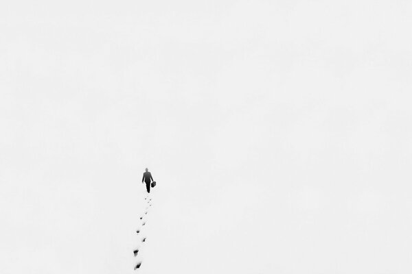 Photo dans le style du minimalisme fait avec un haut, un homme qui marche sur la neige