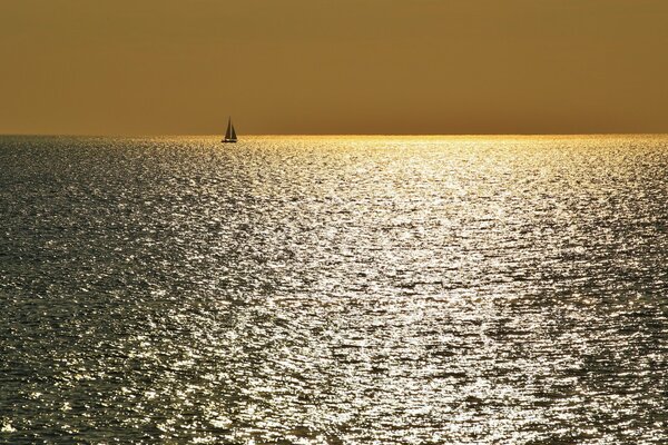 Barco en el mar en el horizonte de la puesta del sol