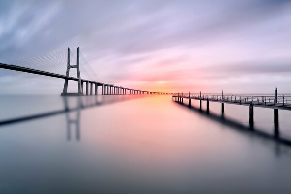 Ponts, plan d eau, soleil couchant, ciel gris