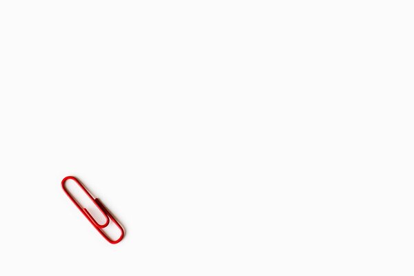 Red paper clip on white background