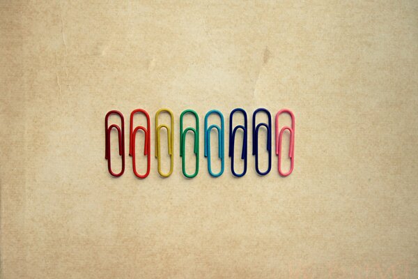Image of multicolored paper clips on a beige background