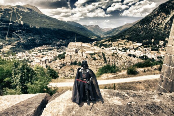 Darth Vader con la spada sullo sfondo della città vecchia e della catena montuosa