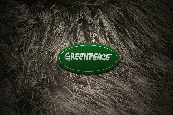 Logo di Greenpeace su sfondo di pelliccia