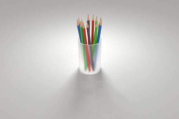 Multicolored pencils in a glass on a gray background