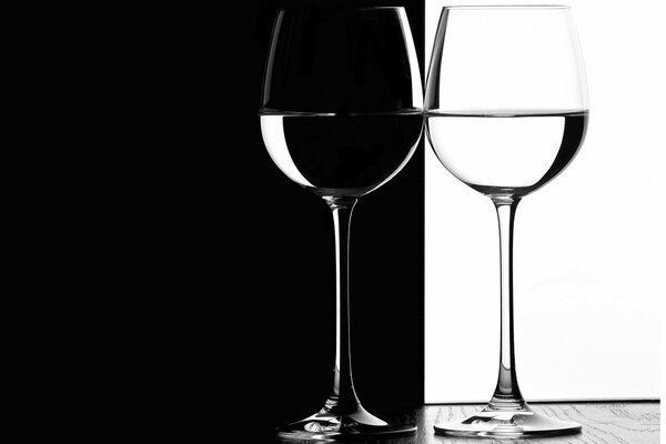 Copas de vino sobre un fondo blanco y negro sobre una mesa de madera