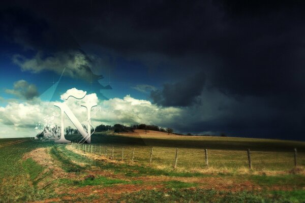 A fence in a field against a dark sky