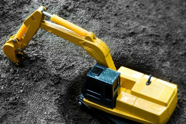 Toy excavator digs the ground vector