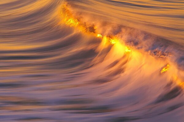 Reflejo de la puesta de sol en la cresta de la ola de mar
