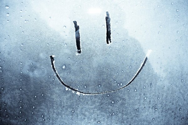 Smiley pintado en el vidrio cubierto de escarcha