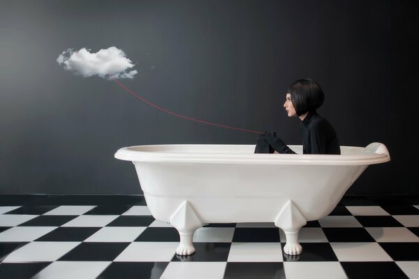 Mädchen im Badezimmer hält eine Wolke an einem roten Faden