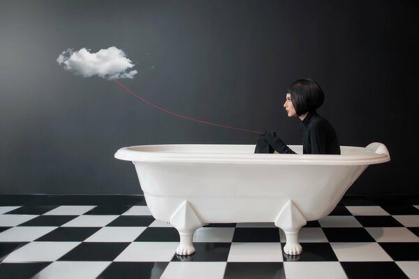 Chica en el baño sosteniendo una nube por un hilo rojo