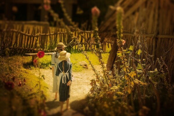 Las chicas del pueblo con sombreros caminan por el camino