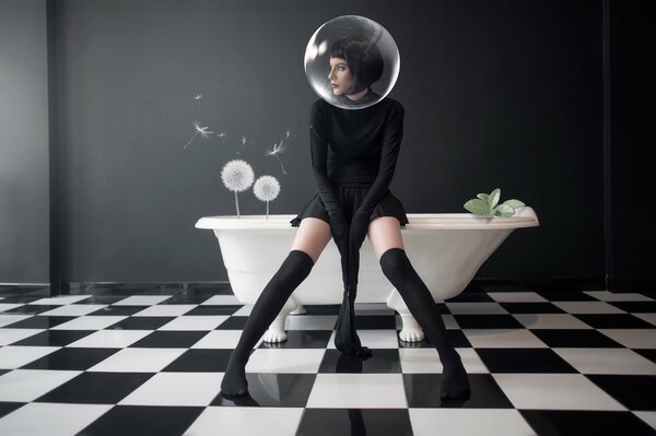 A girl in black in a black and white interior with a bathtub