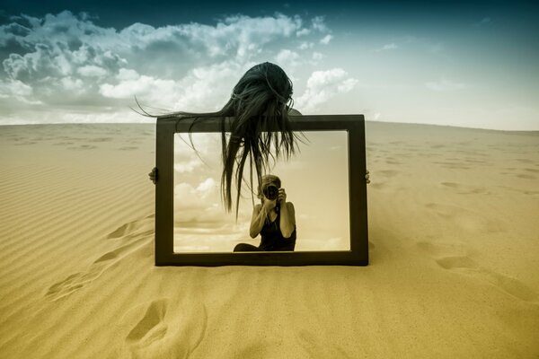 Ragazza con uno specchio nel deserto fotografata