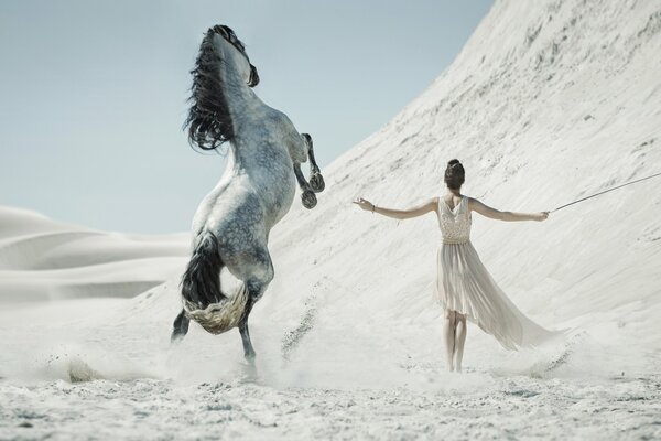 A girl in the desert with a horse