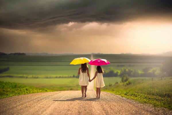 Les deux filles avec des parasols sur la route