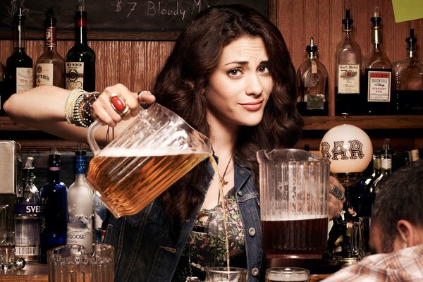 Beautiful girl treats beer at the bar