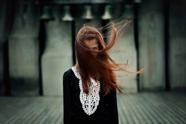 Retrato de una niña con el pelo cubierto en el viento