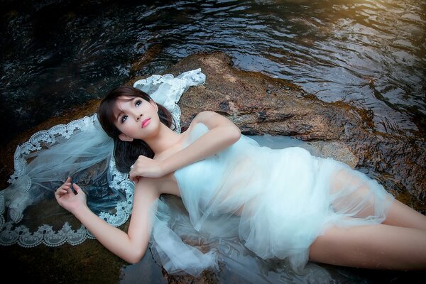 Chica con vestido blanco en la piedra