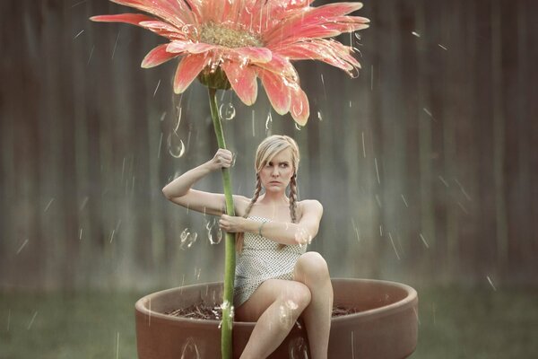 La jeune fille avec une fleur sous la pluie